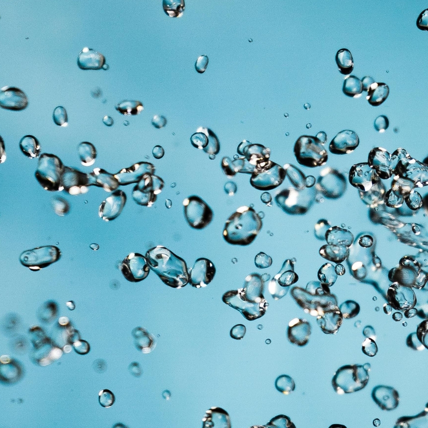 Floating water droplets against a blue background.