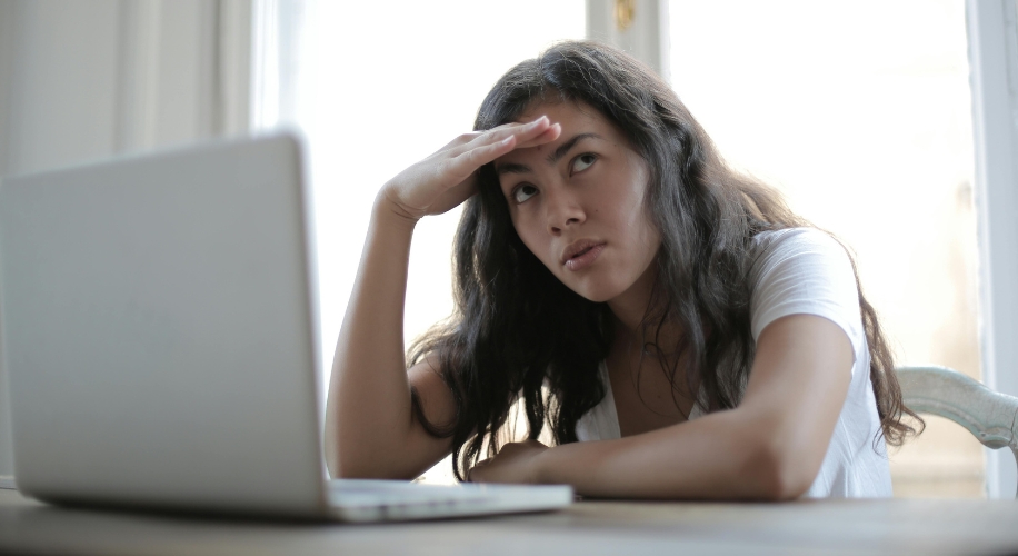 Person looking frustrated while sitting in front of a laptop.