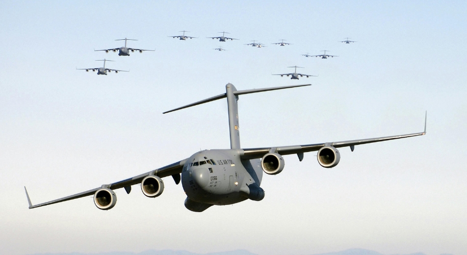 Military transport aircraft flying in formation, front aircraft labeled &quot;U.S. Air Force&quot; and &quot;0066&quot;.