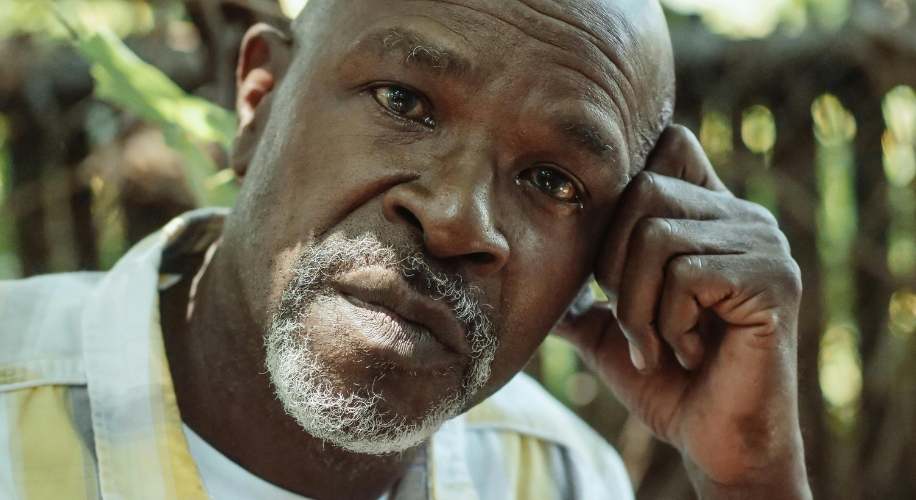 Man with a thoughtful expression resting his head on his hand.