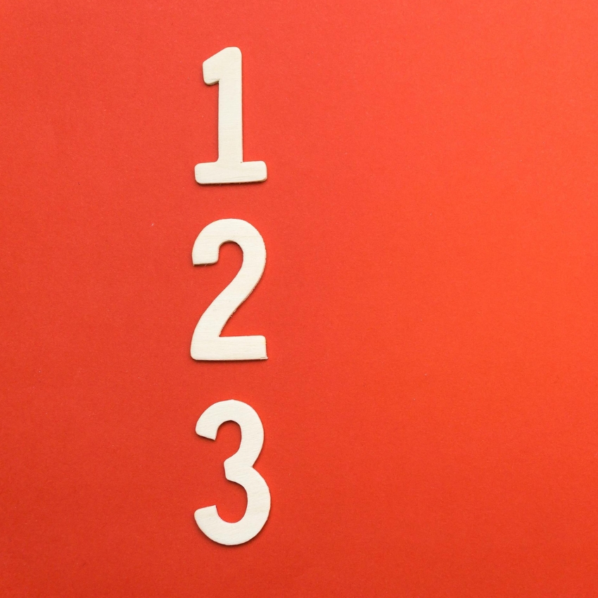 Wooden numbers 1, 2, 3 on a red background.