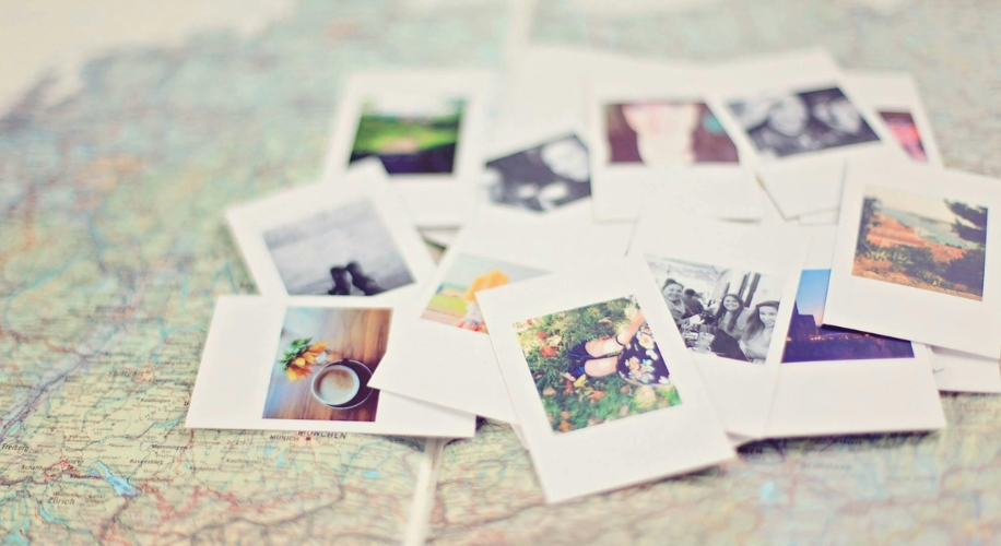 Polaroid-style photo prints scattered on a map background.