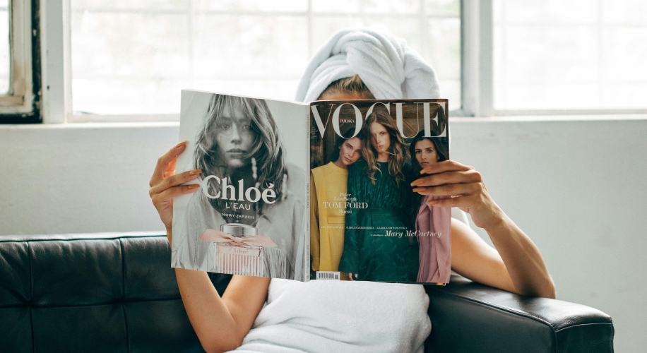 Person reading a VOGUE magazine with &quot;Chloé L&#039;EAU&quot; advertisement on the back cover.