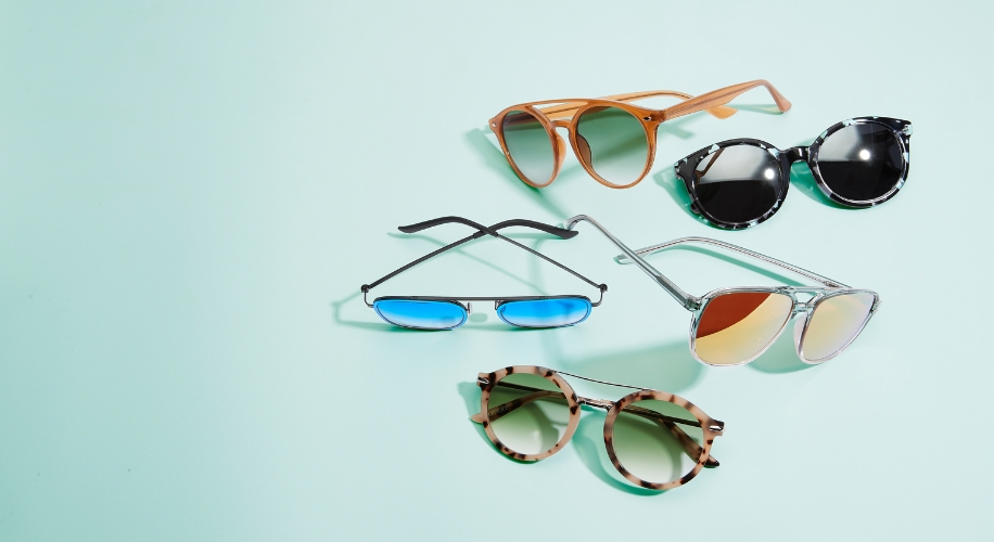 Five pairs of sunglasses in varying styles and colors, including aviator, mirrored, and tortoiseshell frames.