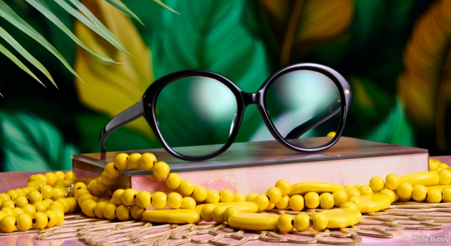 Black round-frame sunglasses atop a colorful box, surrounded by yellow beaded necklaces. Text: &quot;Style: Bubbly&quot;.