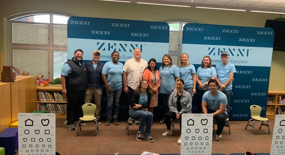 ZENNI Eyewear for Everyone. Group of people wearing ZENNI shirts standing and sitting in front of a ZENNI backdrop.