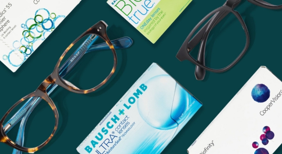 Two pairs of eyeglasses with boxes of Bausch + Lomb Ultra, BioTrue, and CooperVision Biofinity contact lenses.