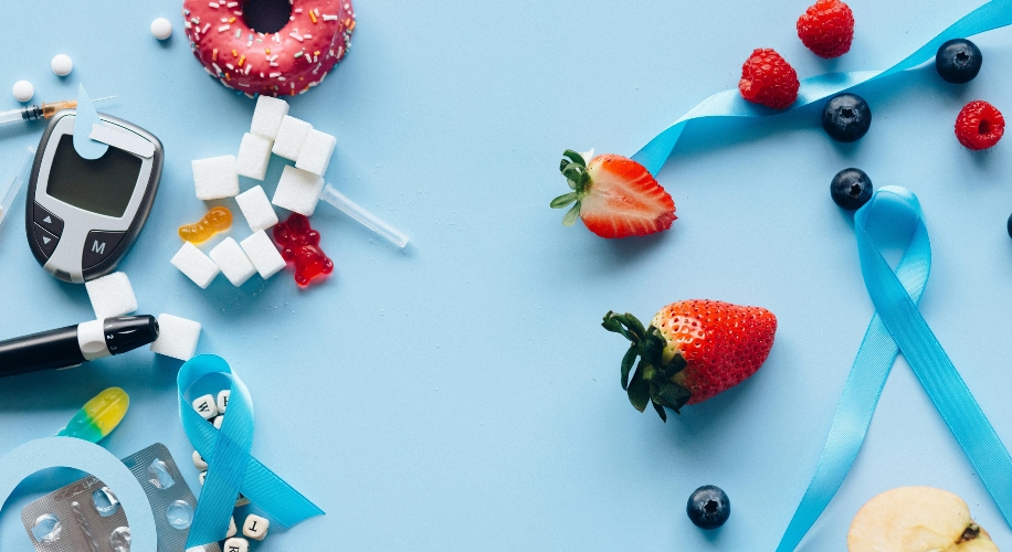 Blood glucose meter, test strips, insulin pen, sugar cubes, colorful candies, strawberries, and a blue ribbon.