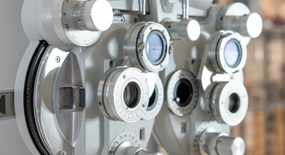 Optometry phoropter with various lenses and dials for vision testing and prescription determination.