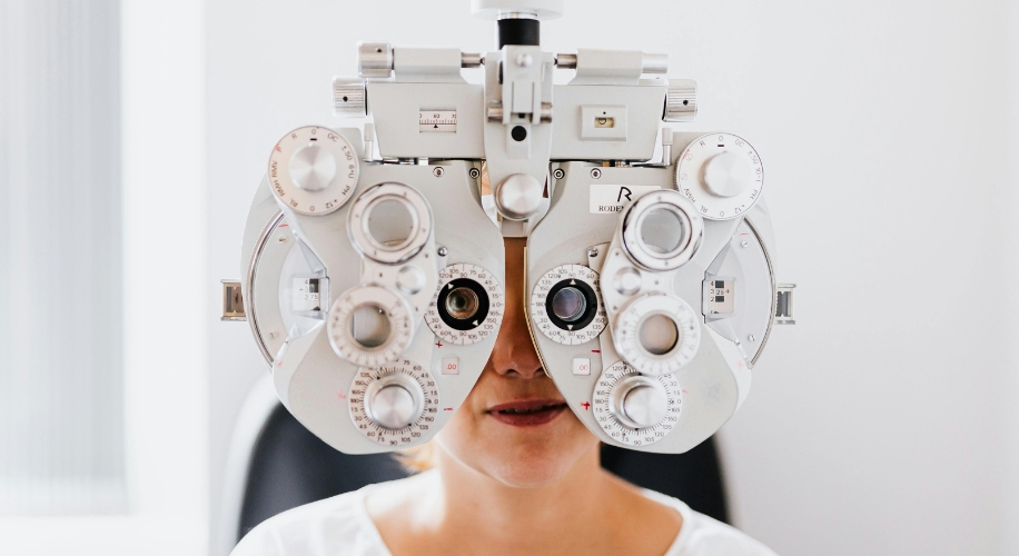 Phoropter during an eye test, partially covering a person&#039;s face.