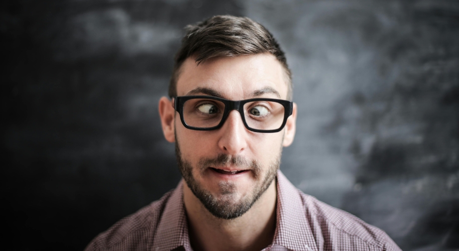 Man wearing black-rimmed glasses with eyes crossed.