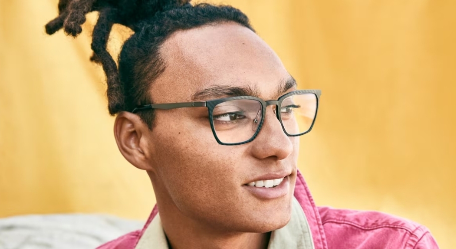 Man wearing black-rimmed glasses and looking to the side.