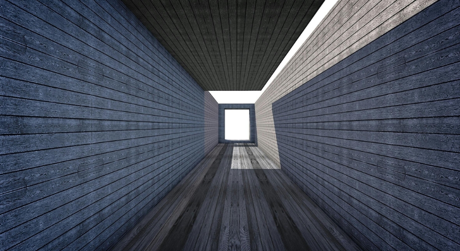 Long corridor with wooden textured walls, ceiling, and floor, leading to a bright window at the end.