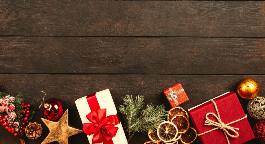 Christmas decorations and gifts, including wrapped presents with ribbons, ornaments, and dried citrus slices.