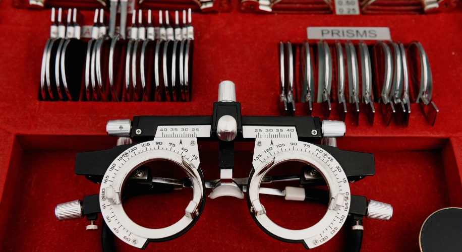 Optometry trial frame set with adjustable lenses and labeled compartments, including &quot;PRISMS.&quot;