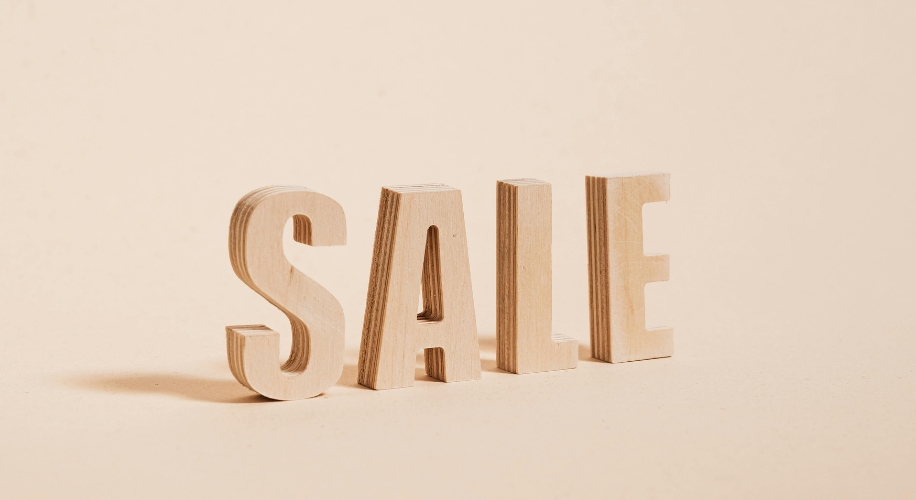 SALE spelled out in wooden block letters.