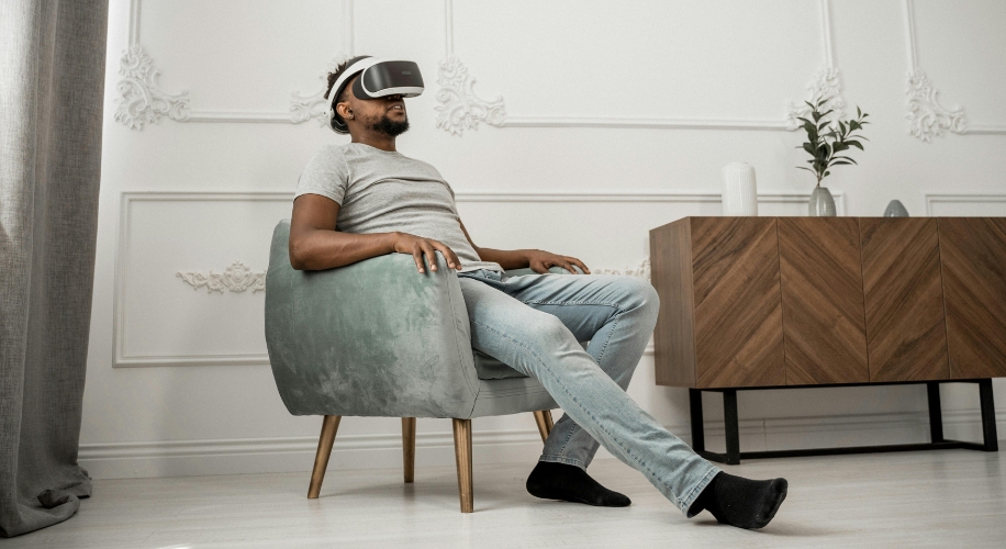 Person using a virtual reality headset while seated in a green cushioned chair.