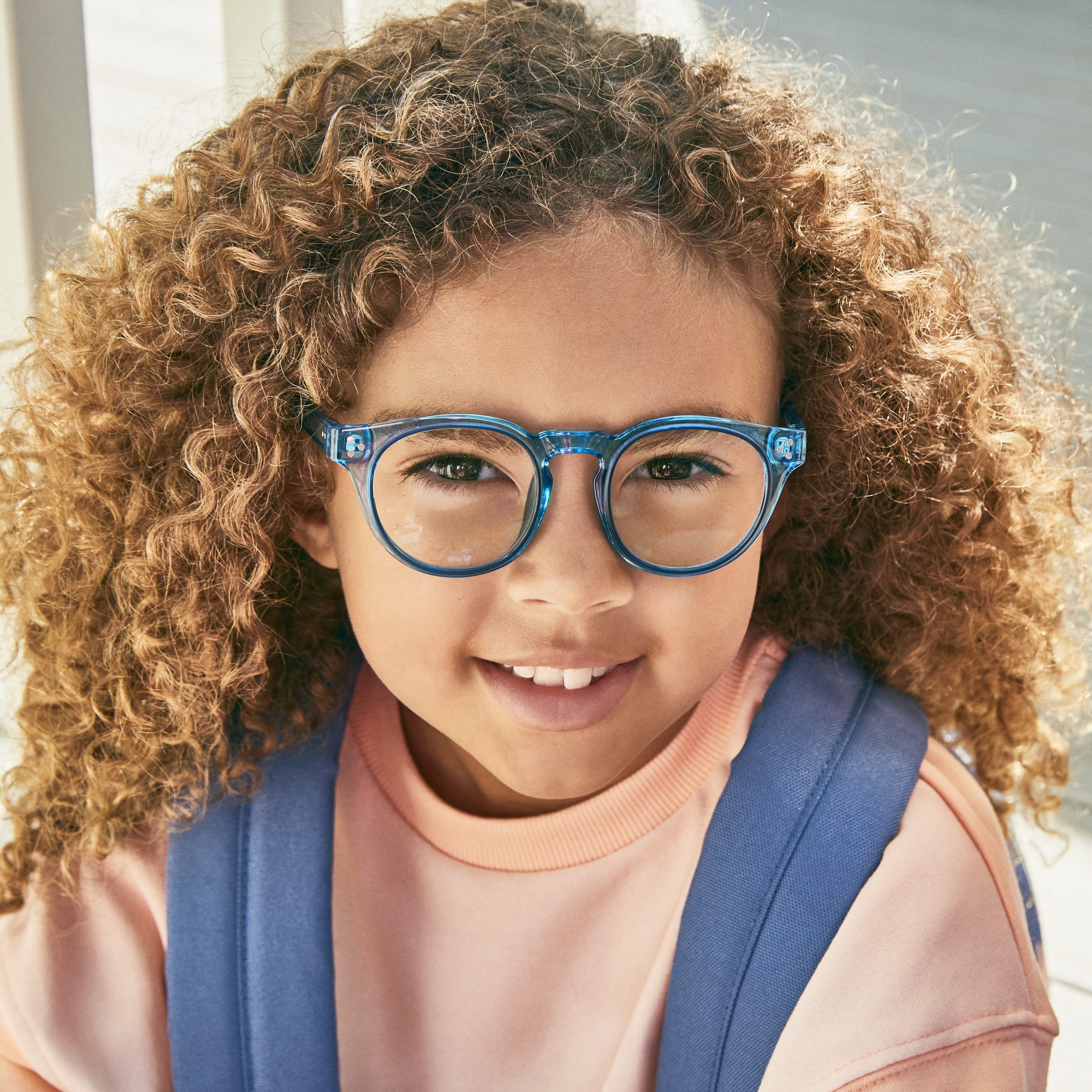 Child wearing blue round glasses.