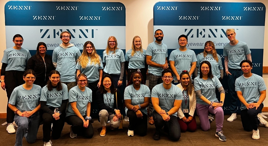 Group wearing blue Zenni t-shirts with &quot;Eyewear for Everyone&quot; text, standing in front of Zenni backdrop.