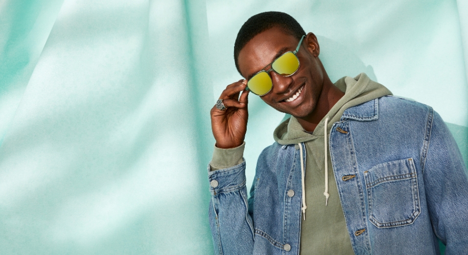 Man wearing a denim jacket and mirrored sunglasses.