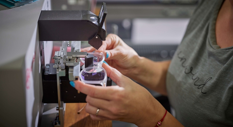 Person aligning lenses in a lens edging machine.