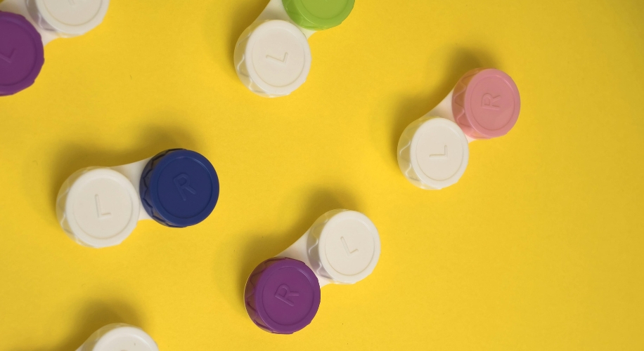 Colorful contact lens cases labeled L and R on a yellow background.