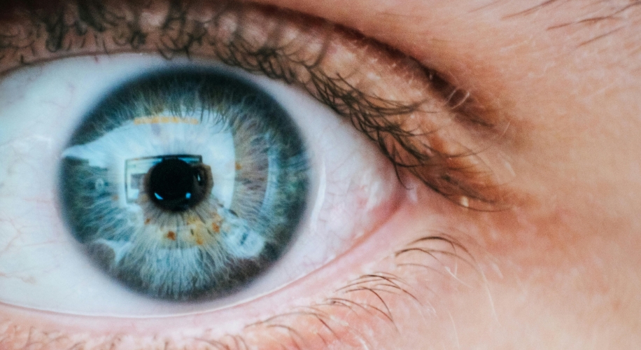 Close-up of a blue eye with detailed iris pattern and reflection.