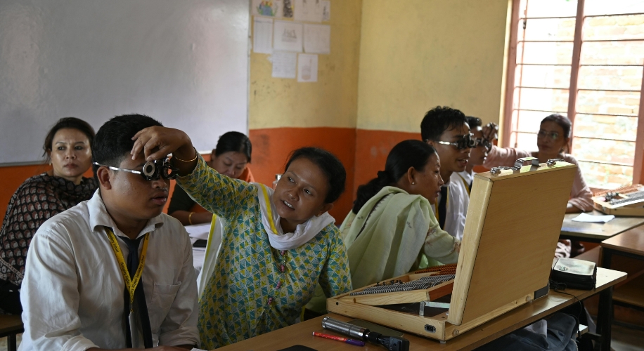 Eye testing glasses being used from an open vision testing kit in a classroom setting.