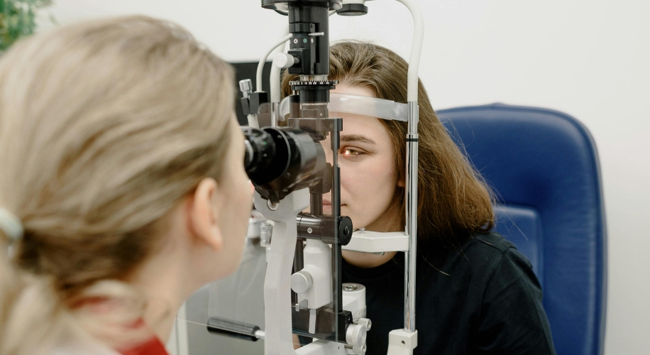 Woman using a slit lamp for an eye examination.