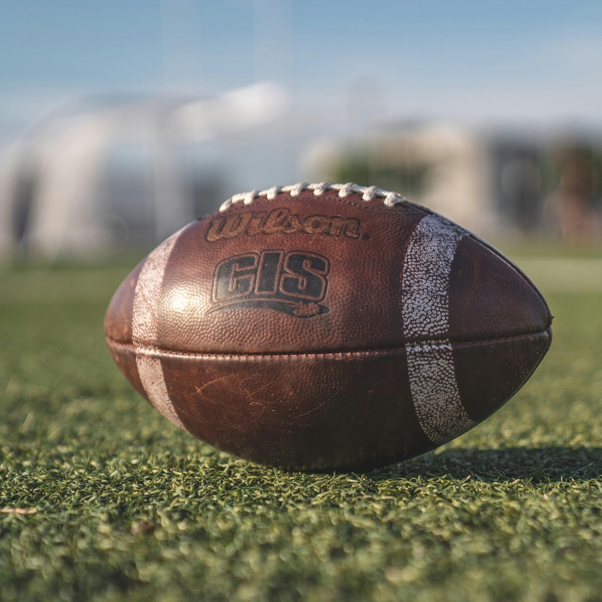 Wilson GIS football on grass field.