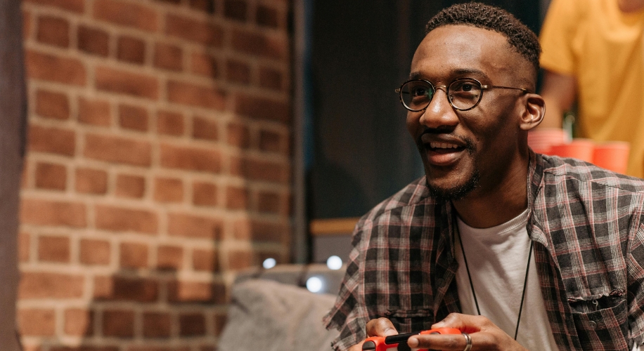 Smiling person holding a red video game controller.