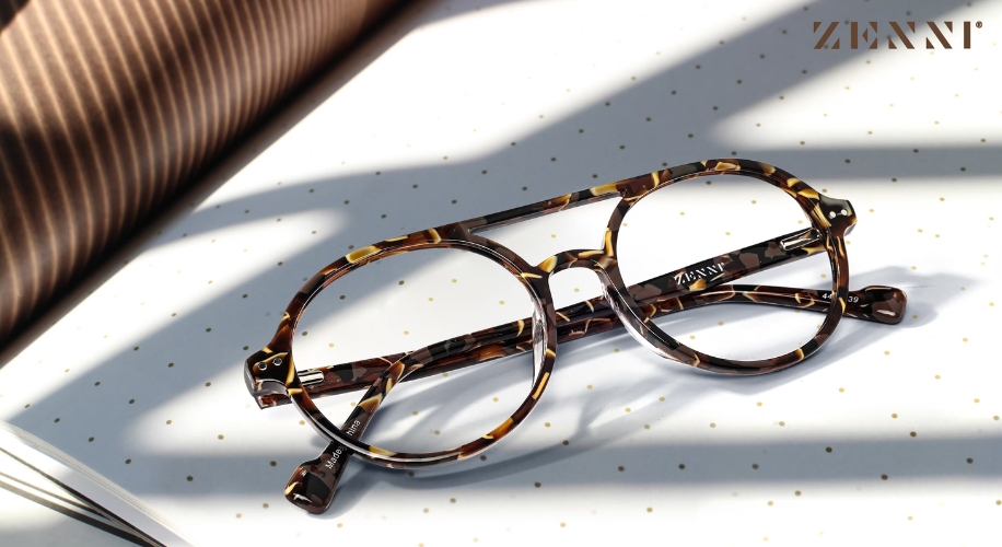 Tortoiseshell round glasses with &quot;ZENNI&quot; logo engraved on the temple, on a dotted surface.