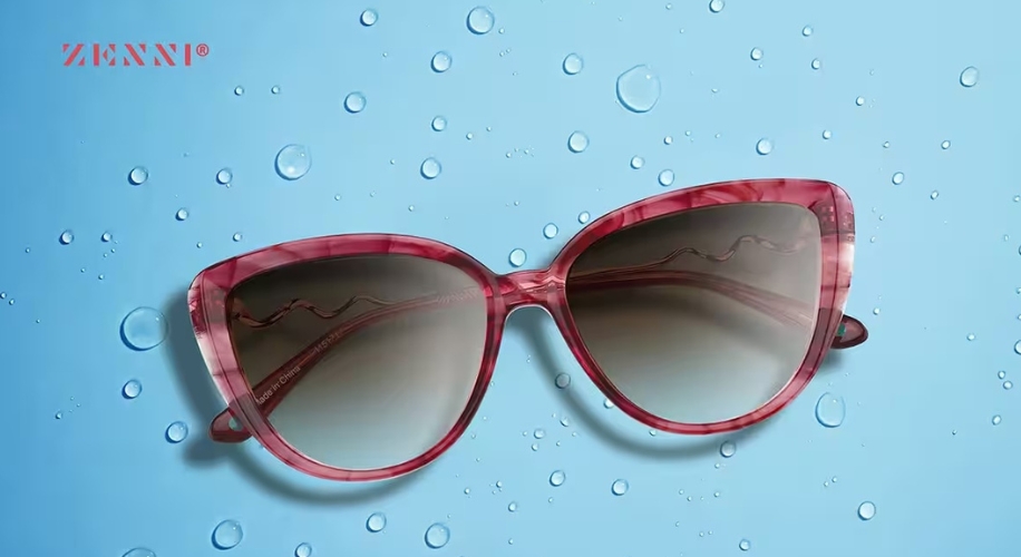 Zenni pink cat-eye sunglasses on a blue background with water droplets.