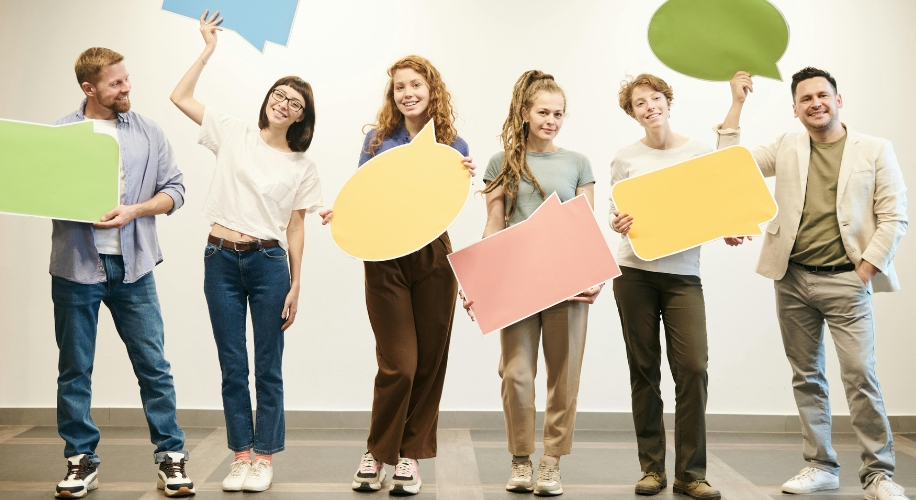 People holding colorful blank speech bubbles.