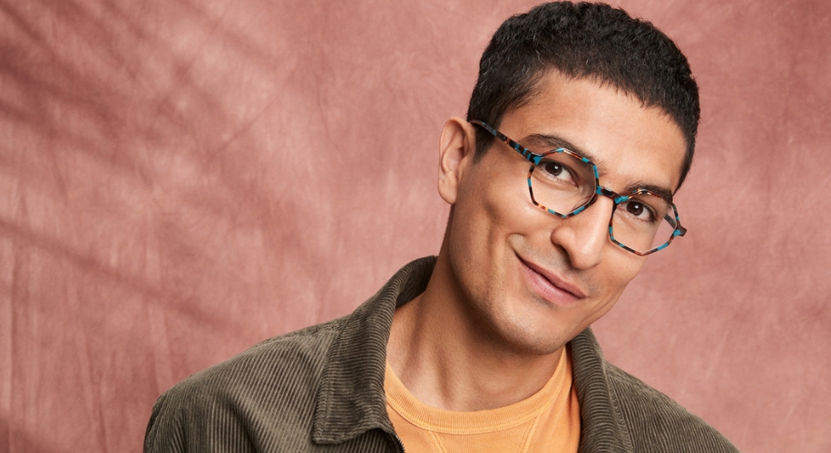 Man wearing tortoiseshell eyeglasses, smiling.