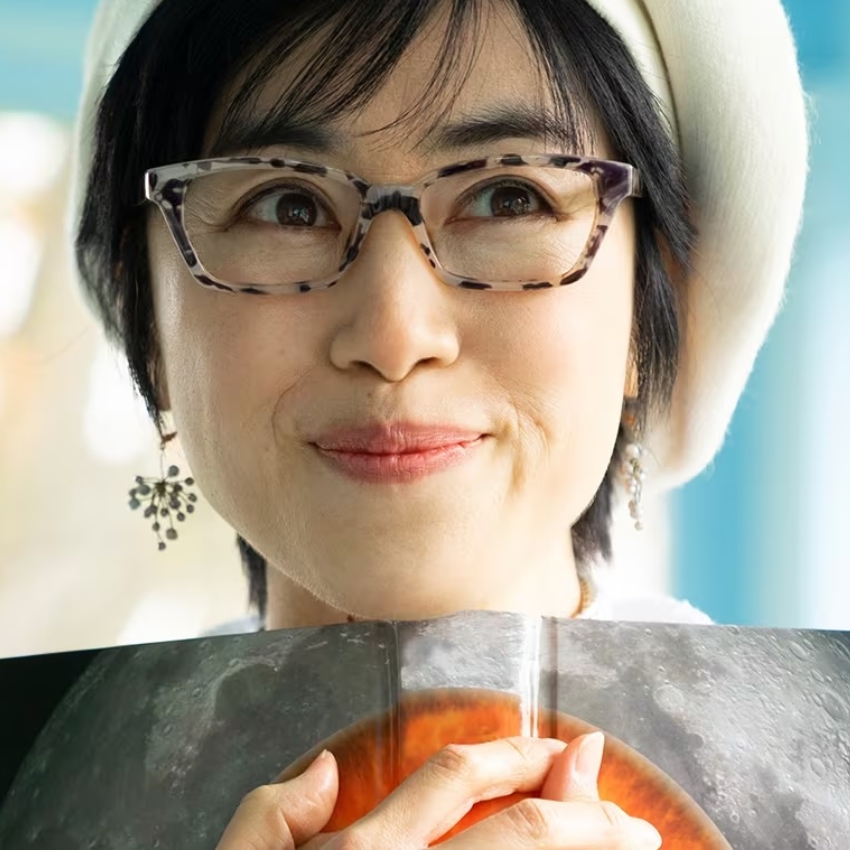 Woman wearing tortoiseshell glasses with a slight smile.