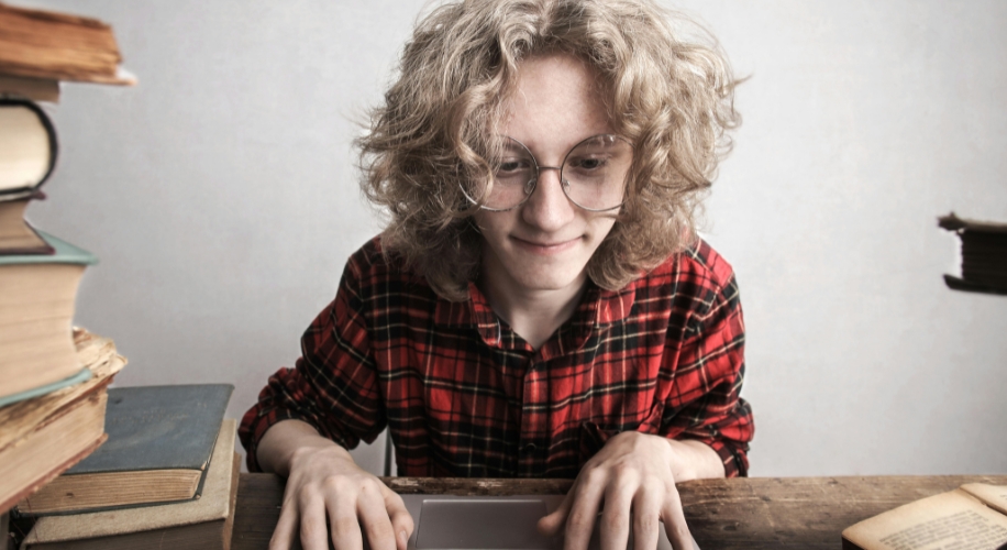 Person in red plaid shirt using a laptop.