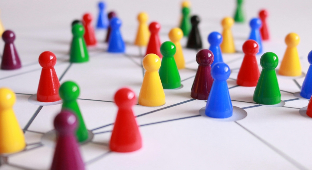 Colorful board game pawns connected by a network of lines.