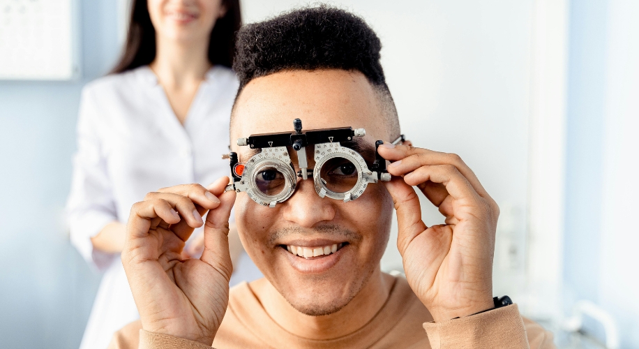 Man smiling while adjusting an optometry trial frame.