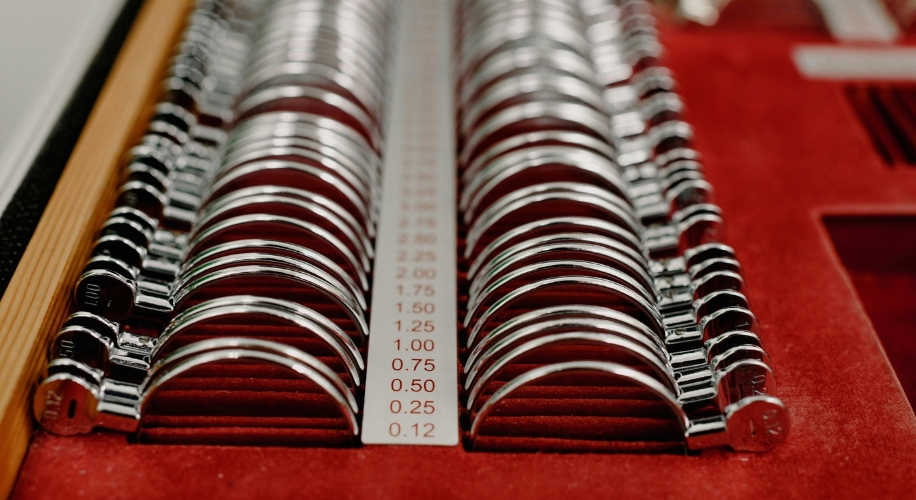 Set of metal trial lens frames on red surface, sizes=