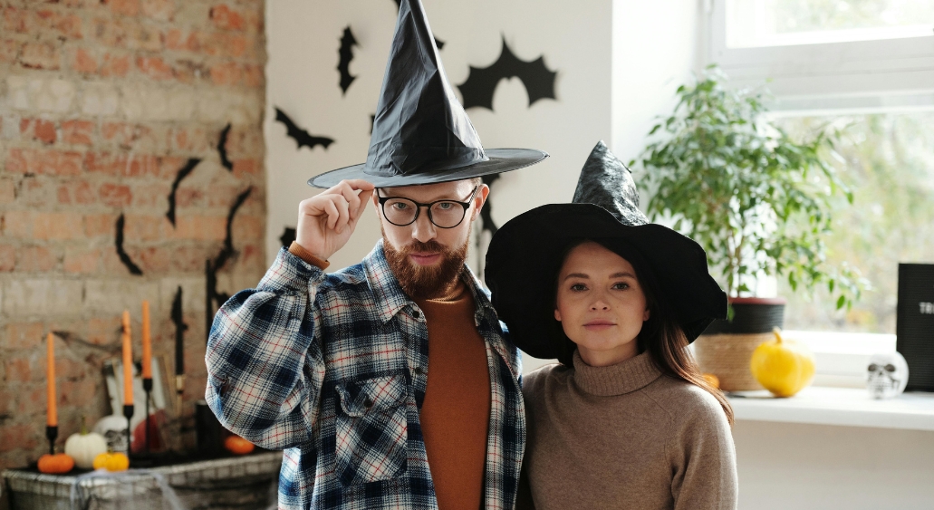 Two people wearing black witch hats.