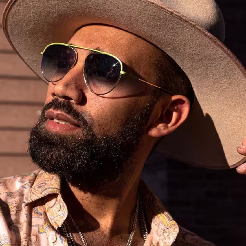 Man wearing sunglasses and a wide-brimmed hat.