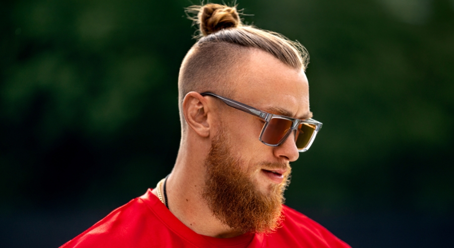 Man wearing rectangular sunglasses with clear frames and tinted lenses.