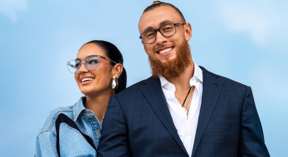 Two people wearing stylish eyeglasses, one in a denim jacket and the other in a dark suit.