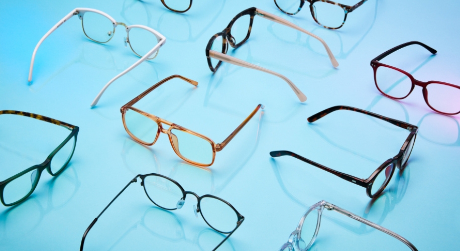 Variety of eyeglasses on a blue surface, including round, rectangular, and cat-eye frames.